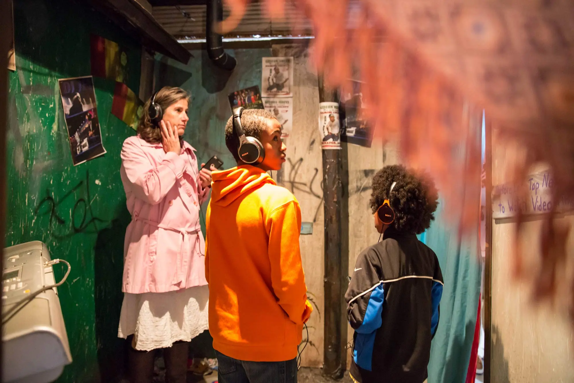 2 boys and a woman listen to the tour audio through their headphones