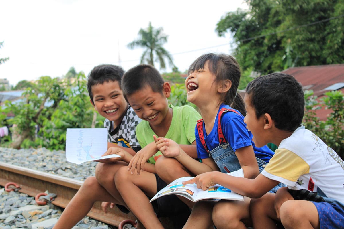 4 children sit and laugh together